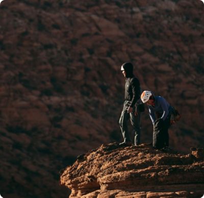 Two climbers in the sun at the top of their climb