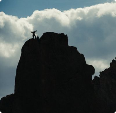 sillhouette of climbers at the top of a ridge