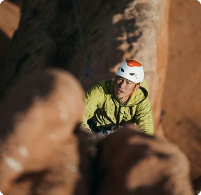 Cody in the light climbing up a rock face