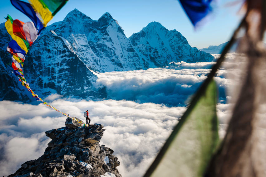 Mountaineering in Nepal, Garrett Madison takes in the view standing on a peak.