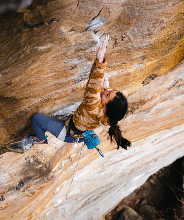 Climbing in the Stretchdown pullover, a climber tries hard for the next hold.