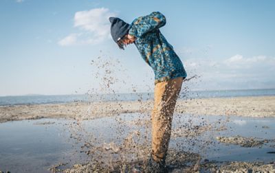 Man jumping in muddy water. 