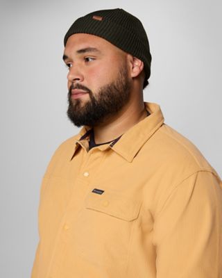 A stylish guy in a yellow shirt jacket and beanie.