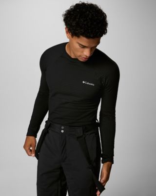 A man in a black ski baselayer and ski pants.