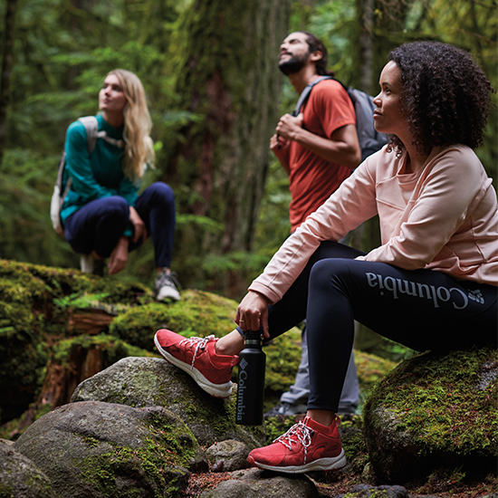 Three friends in hiking sneakers in the forest.