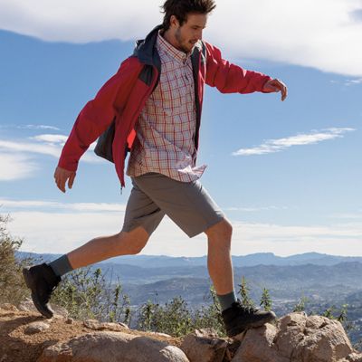 A man in Columbia hiking boots walking over rocks.  