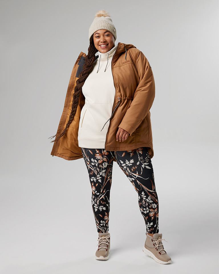 Outfit 3: knit pom pom beanie, long tan insulated jacket over a white hoodie and floral print leggings.