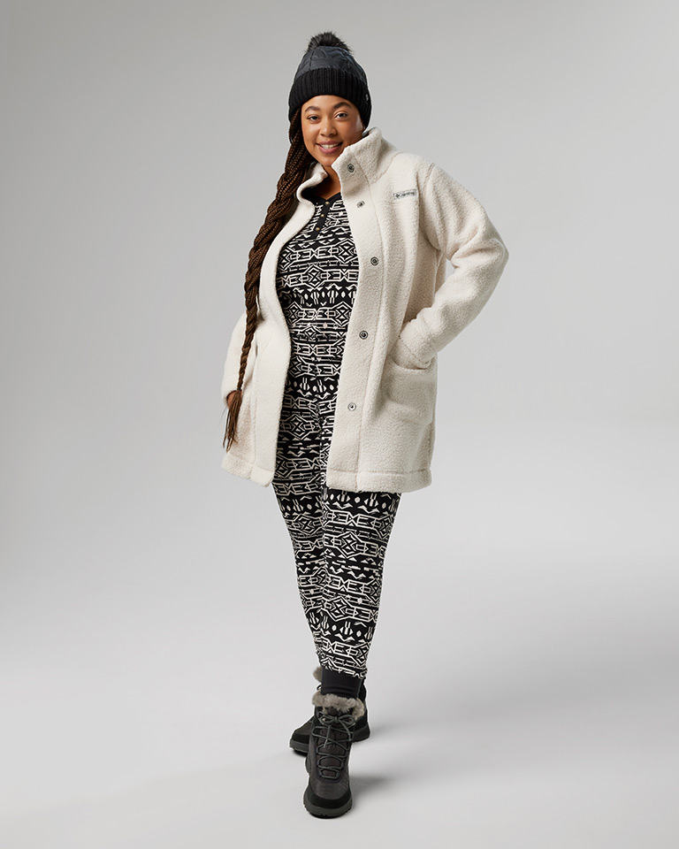 Outfit 6: knit pom pom beanie, black and white printed top and bottom with a white fleece jacket over top, black boots.