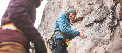 MHW Athlete Alex Johnson chalks up for her next climbing route wearing the Women's Stretchdown™ Hybrid Hoody.