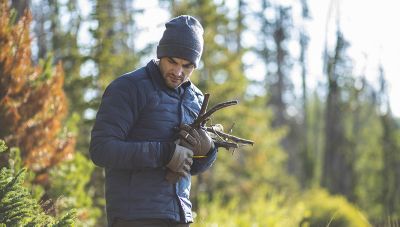 Josh gathers wood near camp wearing the Men's Super/DS™ Stretchdown Climb Shacket