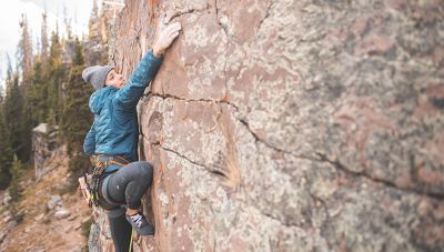 Alex makes her way up the rock while wearing the Stretchdown™ Hybrid Hoody.