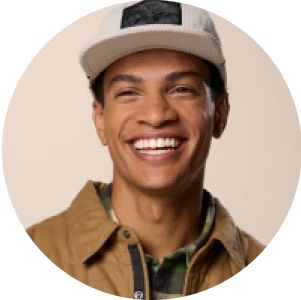 A close-up of a man wearing a Columbia hat and layers.