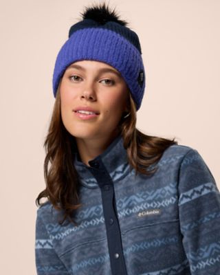A woman smiling in a beanie and cozy fleece jacket.