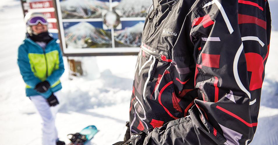 Two snowboarders in Columbia gear at a mountain resort.