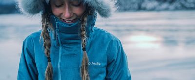 Woman in a blue Columbia parka in the snow.