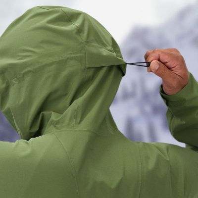 Skier tightening the drawcord on their hood.