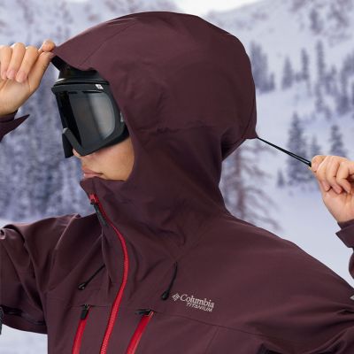 Skier tightening the drawcord on their hood.