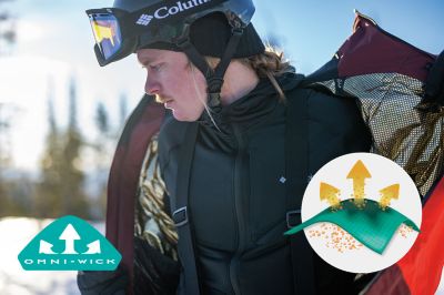 Model in a snowy scene in a jacket featuring Omni Wick sweat wicking tech.