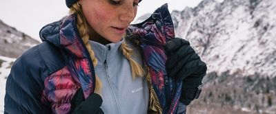 Close up of woman wearing warm coat in a snowy landscape. 