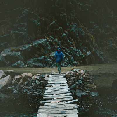 At dusk, walking across an old wooden bridge in a Ghost Whisperer Down Jacket