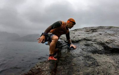 Thor Hesselberg exits the water wearing an orange top and swim cap during the Rockman Swimrun.