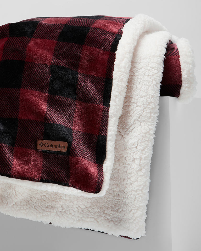 A close up shot of a cozy fleece red plaid blanket.
