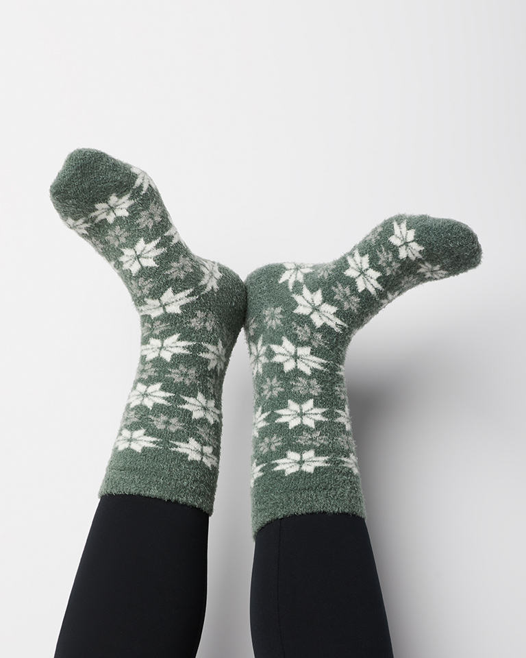 Feet in green and white fleece print socks.