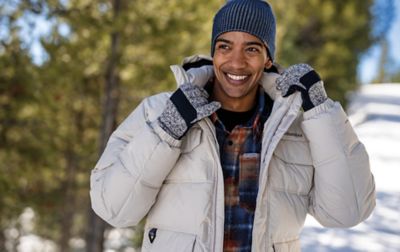 Homme portant une Columbia Puffy Jacket dans une forêt enneigée.