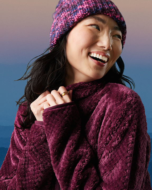A woman in a dark red fleece and beanie.