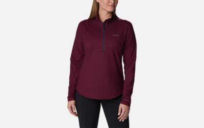 A product image of a woman wearing Columbia Sportswear’s Bliss Ascent Half Zip Shirt against a white background. 