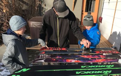 People waxing skis.
