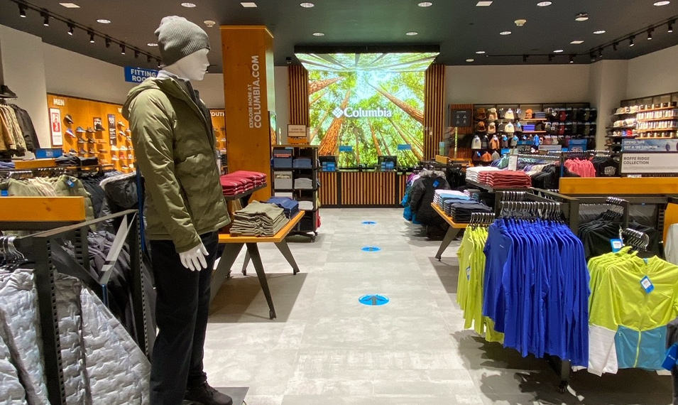 Interior of a Columbia retail space with a dressed mannequin and racks of clothes. 