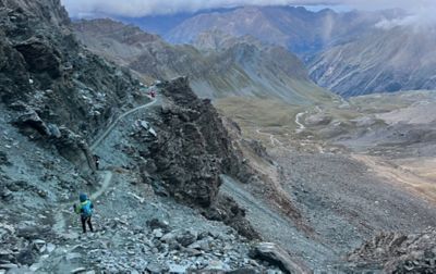A long-distance runner in the 200-mile Tor des Géants race stands alongside the narrow rock strewn trail.
