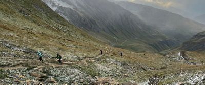Runners make their way up a narrow dirt trail in Italy's vast, windswept Aoste Valley. 