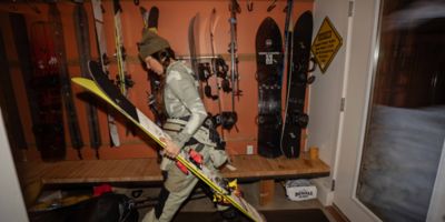 MHW athlete Rachael Burks walking in from the slopes with skis in hand.