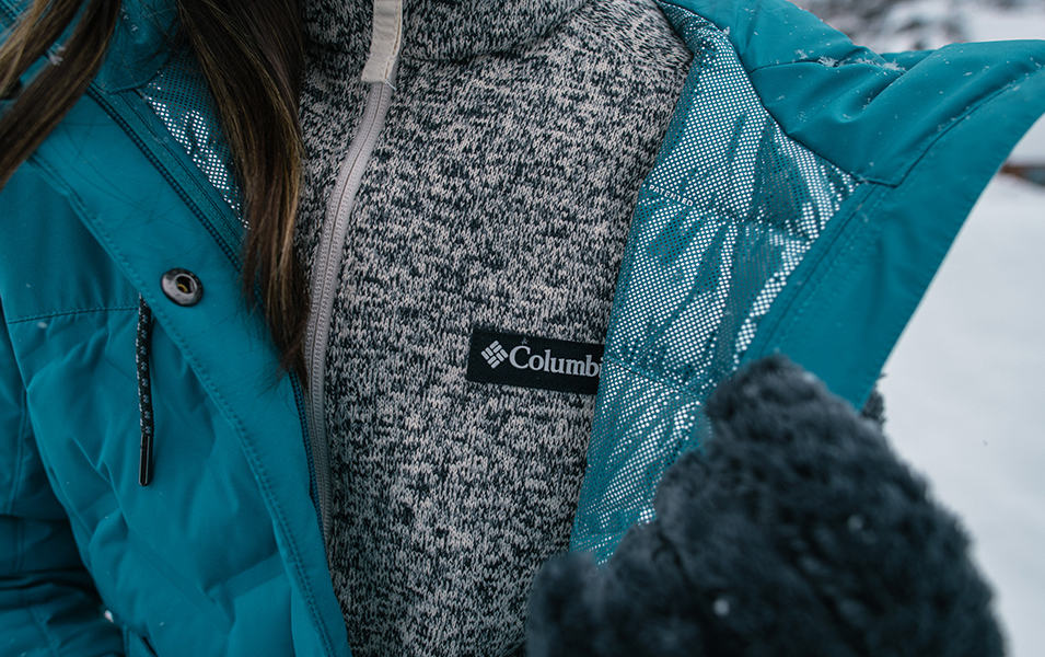 A close-up shot of a gray knit midlayer underneath a blue Columbia Sportswear jacket. 