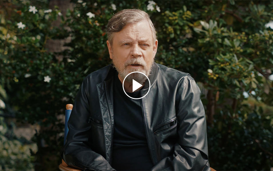 Video still of Mark Hamill discussing the collaboration between Star Wars and Columbia. Play button. 