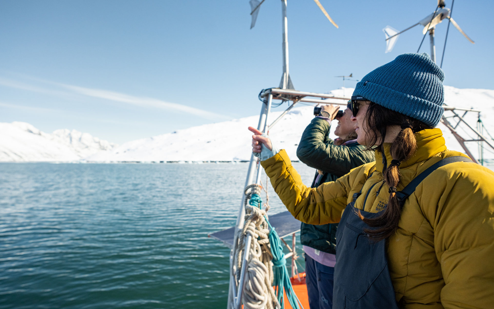 Profile shot of Rachael wearing a Stretchdown jacket and bib on the sailboat, looking out.
