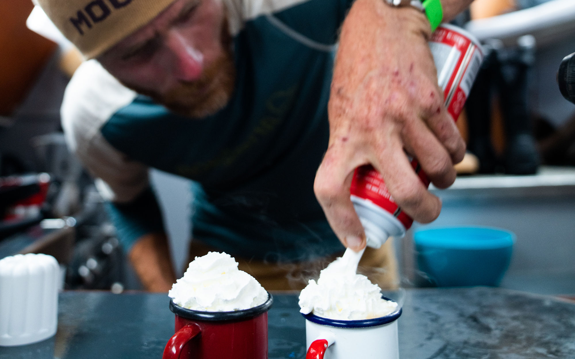 Captain Ben fixes up two hot chocolates, topping off both mugs with whipped cream.