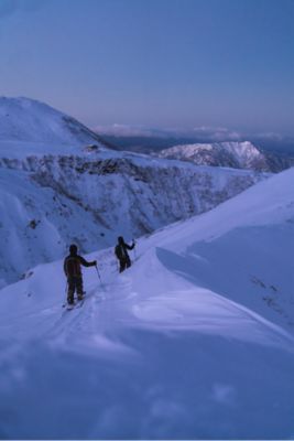 Daisuke Mizuma and Keisuke Yoshida skin in on their approach at dusk to ski Big Day mountain in Japan.