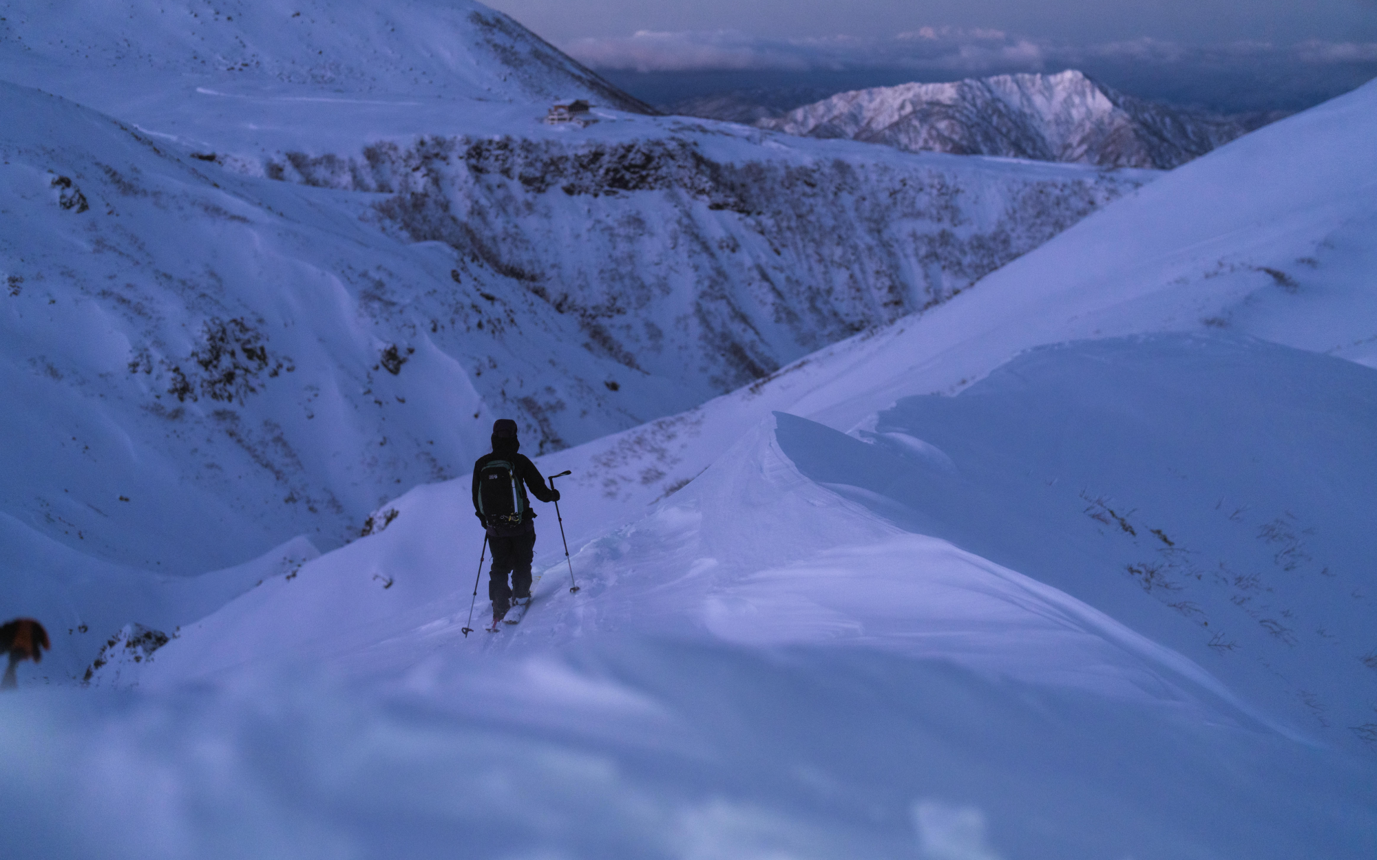 Keisuke takes in the view at dusk while skinning into the top of the run at Big Day mountain.