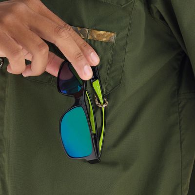 Close-up of a model attaching a pair of sunglasses to the utility loop.