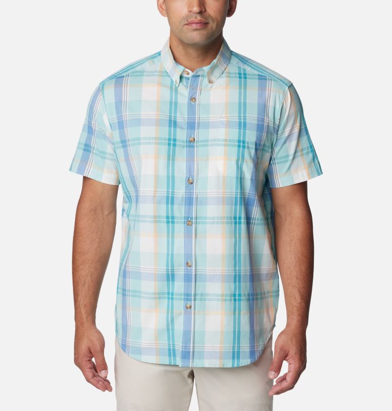 Man in blue and white plaid dress shirt and brown pants fishing on