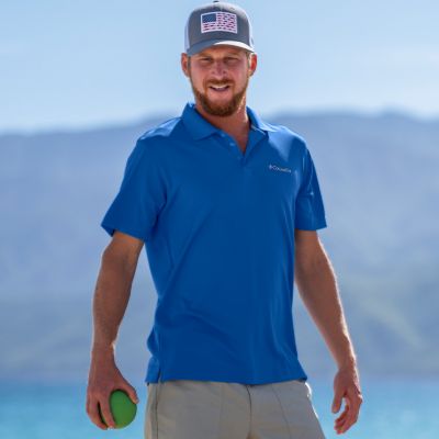 A man on the beach playing a game wearing a polo shirt
