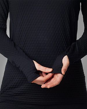Model showing the thumbholes of a baselayer top.