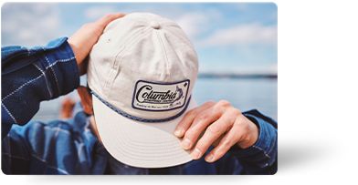A man posing with a ball cap on.