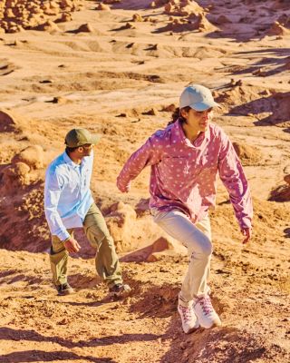 Two hikers walking in a desert landscape.