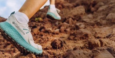 Someone in Konos hiking shoes on a trail.