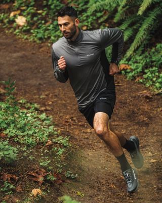 A man running down a trail switchback looking cool.