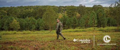 Country Western Superstar, Luke Combs, wears Columbia’s Luke Combs Turkey Hunting Collection, as he walks through a green field, ready for the hunt.